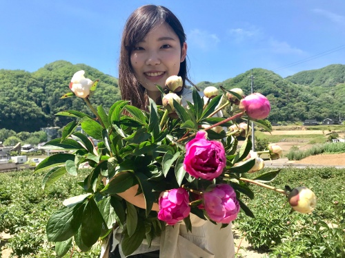 シャクヤクの花を持つ熊澤リポーター